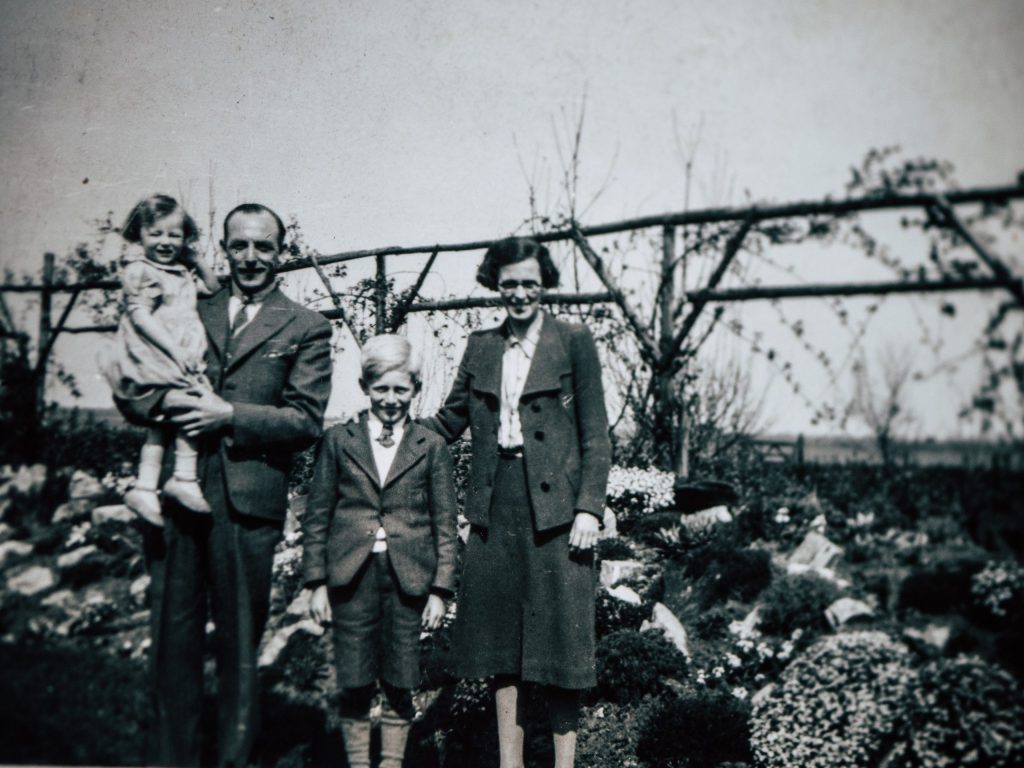 Old family photographs arranged on a table representing genealogy research